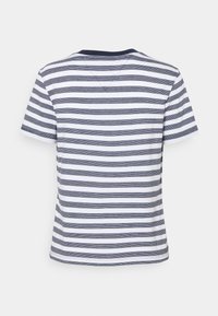 Vit T-shirt med kort ärm som har marinblå horisontella ränder och marinblå krage, sedd bakifrån på en enfärgad vit bakgrund.
