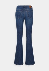 Jean en denim bleu foncé avec taille haute, poches arrière et jambes évasées, vu de dos sur un fond uni.
