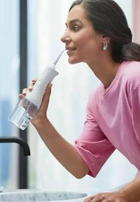 Oplaadbare waterflosser met een witte ergonomische handgreep, heldere watertank en een lange, dunne spuitmond voor gerichte reiniging.