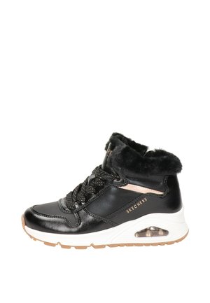 Zapatillas negras de caña alta con cuello de pelo sintético, detalles de malla y cordones texturizados. La entresuela blanca cuenta con amortiguación de aire visible y suela color marrón.