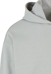 Lys grå hættetrøje med en glat tekstur og ribbet krave. Har en afslappet pasform og minimalistisk design.