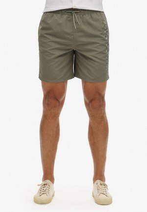 Shorts de bain vert olive en tissu léger, avec une taille élastique à cordon de serrage et un détail de logo sur le côté.