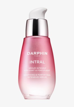 Sérum intensivo calmante y fortalecedor Darphin Intral en un frasco con bomba de gradiente rosa con dispensador plateado y blanco.
