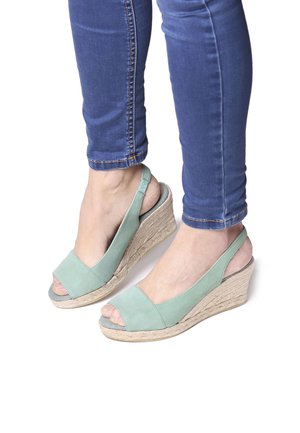 Sandali con zeppa in suede verde con punta aperta, dotati di una suola avvolta in juta e design slingback. Texture in suede, forma elegante.