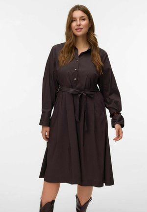 Robe chemise marron foncé avec une taille ceinturée, un devant boutonné et des manches longues. Fabriquée en tissu lisse avec une jupe fluide et des accents aux poignets.