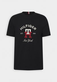 Černé bavlněné tričko s vyšitým logem "HILFIGER New York". Kulatý výstřih s červenými a bílými akcenty. Klasický střih. Krátké rukávy.