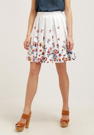 Witte plissé rok met een bloemenpatroon in rood, blauw en geel. Gemaakt van lichtgewicht stof. Heeft een aansluitende tailleband.