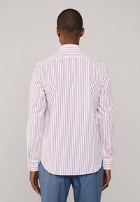 Chemise blanche à rayures verticales rouges, manches longues, poignets à bouton, et col classique. Texture lisse, coupe ajustée, vue arrière.