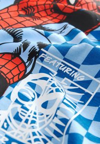 Tessuto multicolore con grafiche di Spider-Man in rosso e nero su uno sfondo a quadretti blu con accenti bianchi e testo.