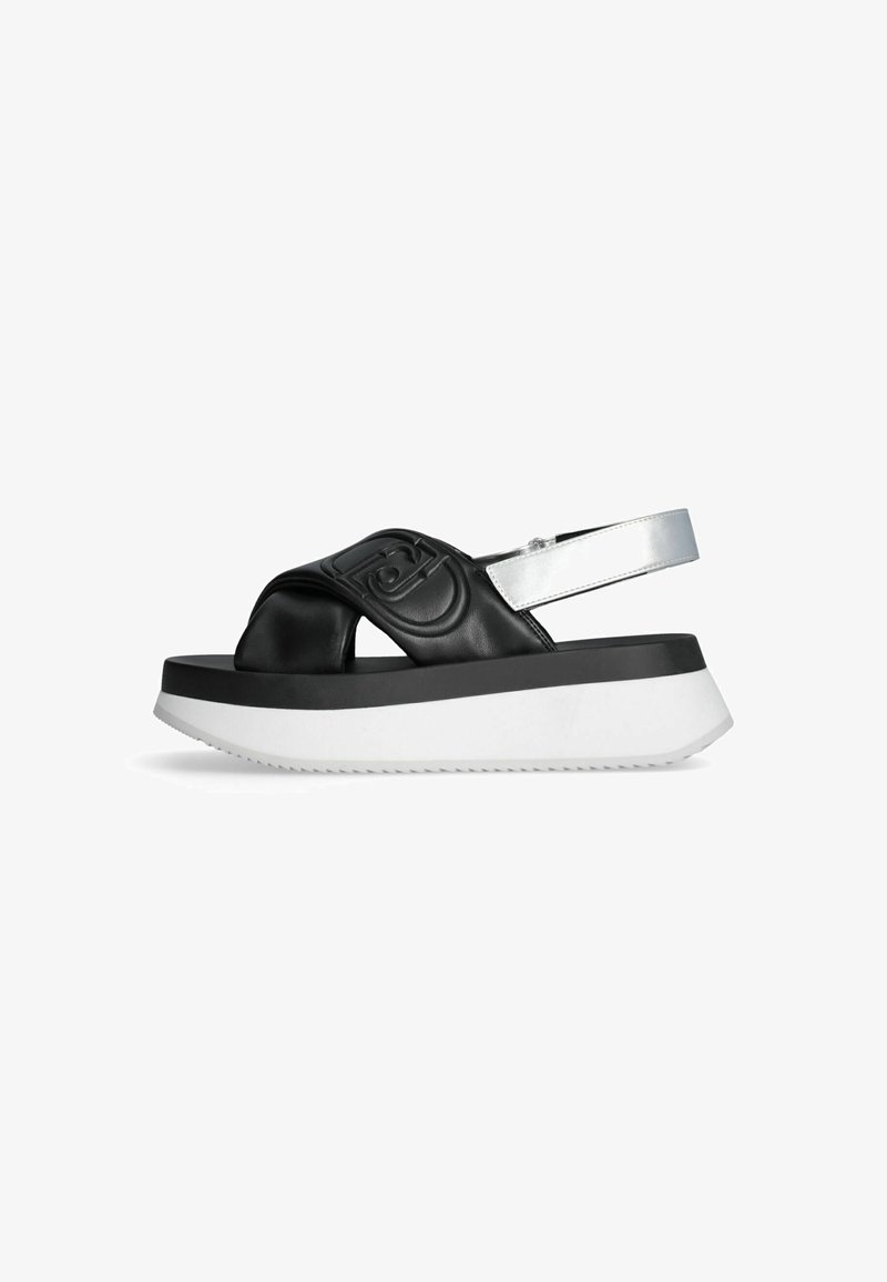 Sandali platform sintetici neri con una larga fascia testurizzata e dettagli in argento, caratterizzati da una spessa suola bianca con un motivo zigzag.