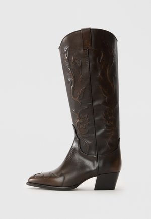 Botte western mi-mollet en cuir brun foncé avec un bout pointu, un petit talon empilé bas, et une broderie florale décorative sur la tige et le bout.