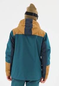 Teal, navy, and brown color-blocked jacket with a hood, made of waterproof material; features textured fabric and adjustable cuffs.