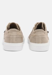 Beige Segeltuch-Sneaker mit ausgefransten Kanten, abgerundetem Hinterteil und weißer Gummisohle. Sie zeichnen sich durch ein minimales Design aus, ohne sichtbare Logos oder Muster.