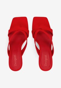 Rote Sandalen mit offenen Zehen und quadratischem Absatz, mit gekreuzten Riemen und einer glatten Textur. Markenzeichen auf der Innensohle gedruckt.