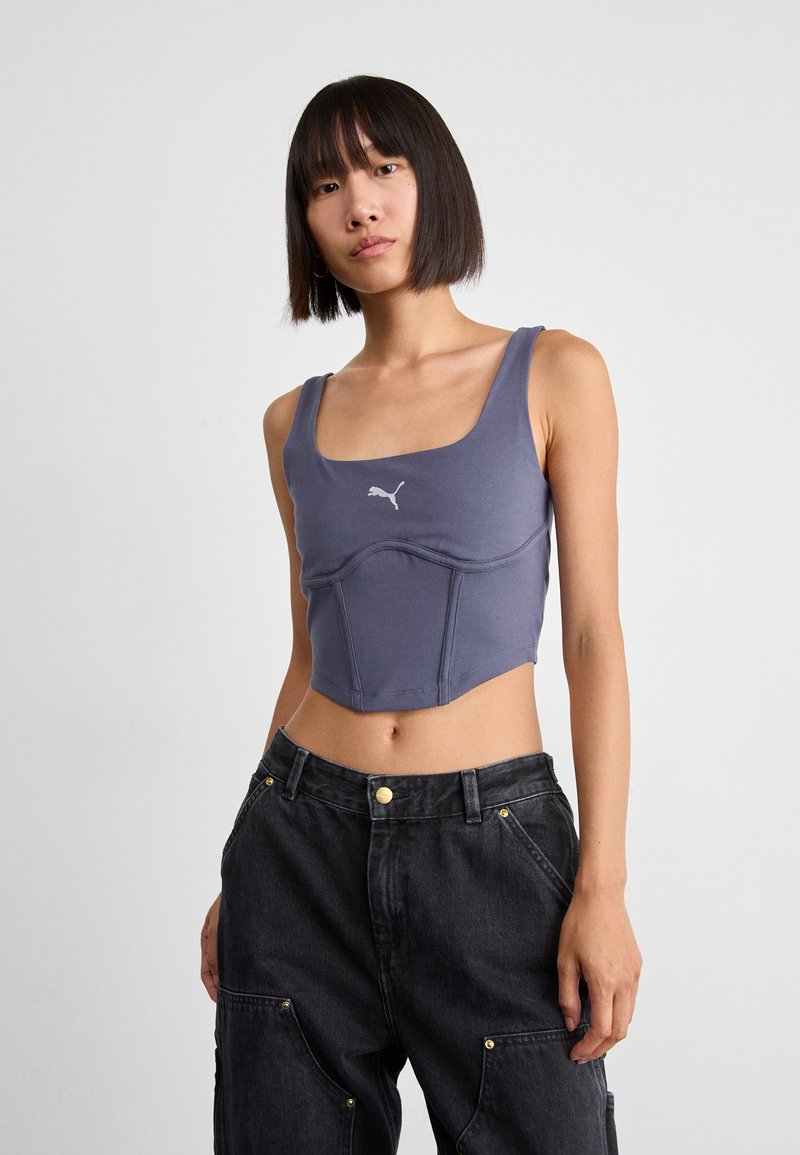Grijze crop top met een vierkante halslijn; fitted ontwerp met gestructureerde naden; bevat een klein wit logo in het midden. G draagt het met een donkere cargobroek.