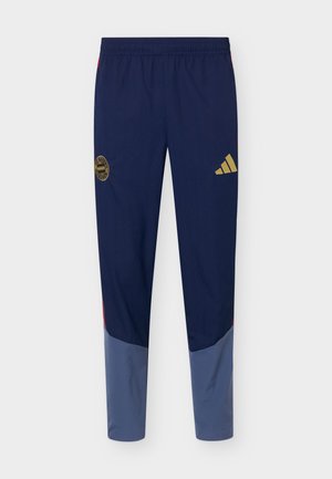 Pantaloni sportivi blu navy e grigio con vita elastica, logo adidas dorato sulla coscia destra e stemma dorato del Bayern Monaco sulla coscia sinistra.