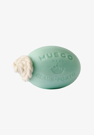Ovale lichtgroene stukzeep met gegraveerde tekst "MUSGO REAL CLAUS-PORTO" en een wit gevlochten touw eraan bevestigd.