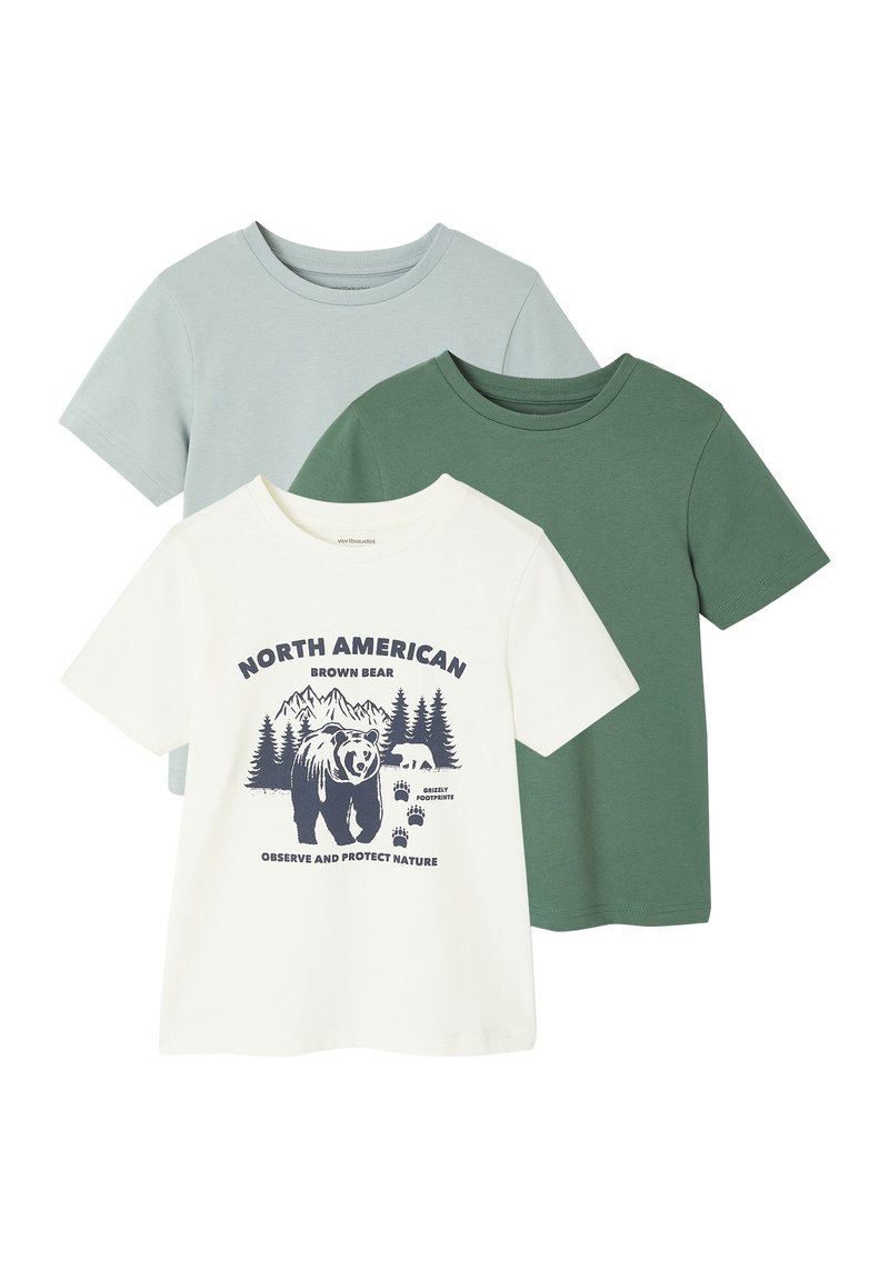 Three t-shirts in light blue, green, and cream, featuring a graphic print of a brown bear and trees on the cream shirt.