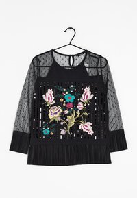 Zwarte blouse met transparante lange mouwen met stippen, geborduurd bloemenmotief met kleurrijke accenten, pailletten en een geplooide onderrand.