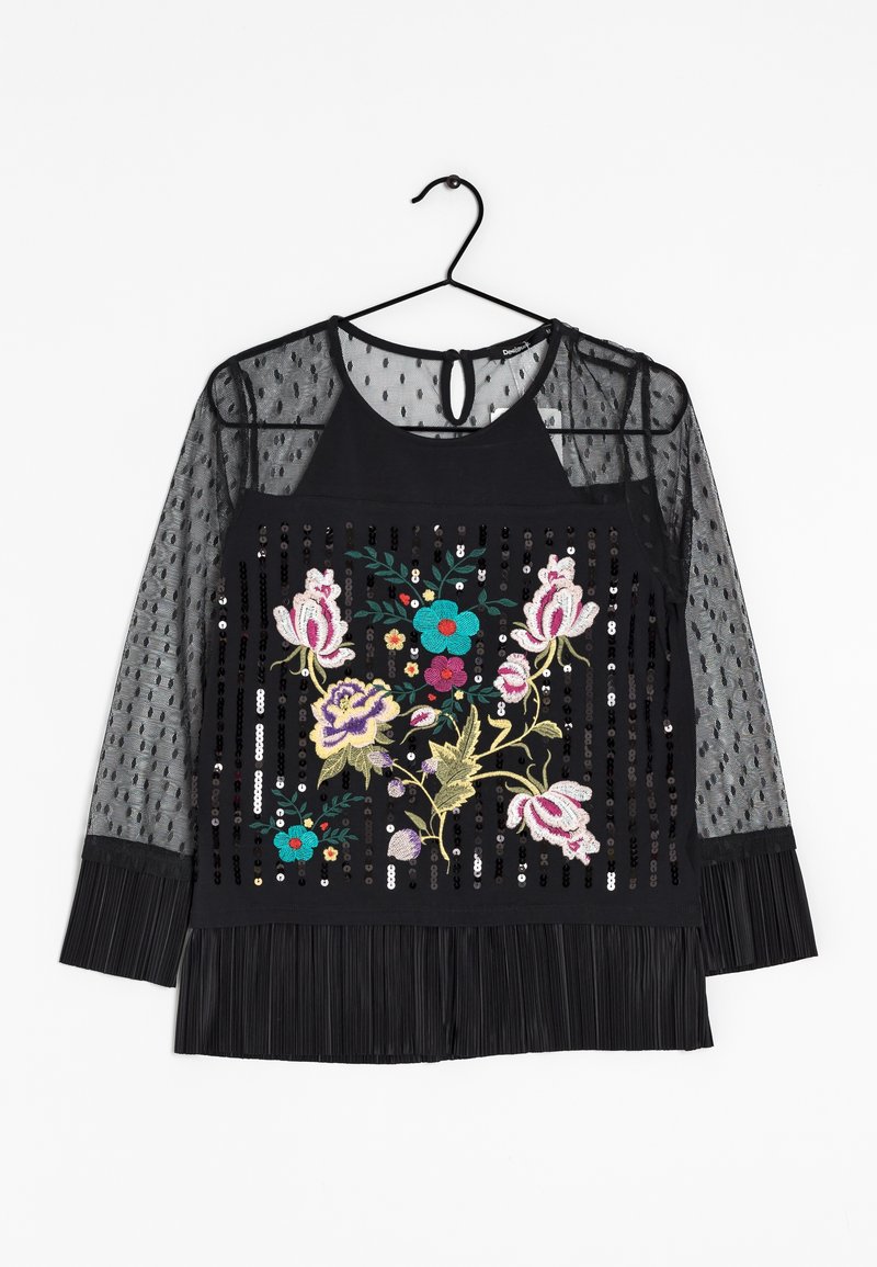 Zwarte blouse met transparante lange mouwen met stippen, geborduurd bloemenmotief met kleurrijke accenten, pailletten en een geplooide onderrand.