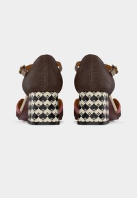 Καφέ δερμάτινα παπούτσια με τακούνι, με υφή στην επιφάνεια, ροζ λεπτομέρειες και ασπρόμαυρο τακούνι σε σχέδιο μπλοκ με ζιγκ-ζαγκ μοτίβα.