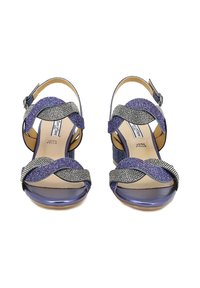 Due sandali con tacco alto, dotati di cinturini testurizzati multicolore in blu, argento e nero. Presentano un tacco a blocco viola e una chiusura con fibbia alla caviglia.