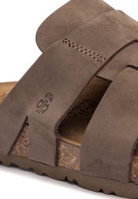 Sandal de ante marrón con correas entrelazadas, planta texturizada, medio suelo de corcho y suela de goma definida. Logo sutil grabado en el lateral.