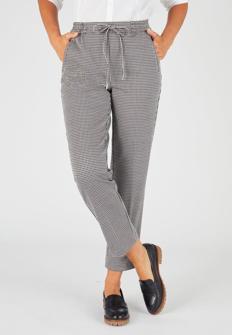 Schwarz-weiße, kariert gemusterte Hose mit einem elastischen Bund und Kordelzug, zwei Seitentaschen und schmal zulaufenden Beinen.