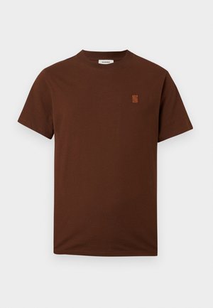 Camiseta marrón de manga corta y cuello redondo con pequeño logotipo bordado en el pecho izquierdo sobre un fondo liso.