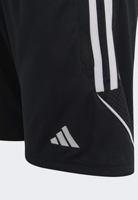 Schwarze Sportshorts mit weißen Streifen an den Seiten, Netzeinsätzen und einem silbernen gestickten Logo am unteren linken Bein.