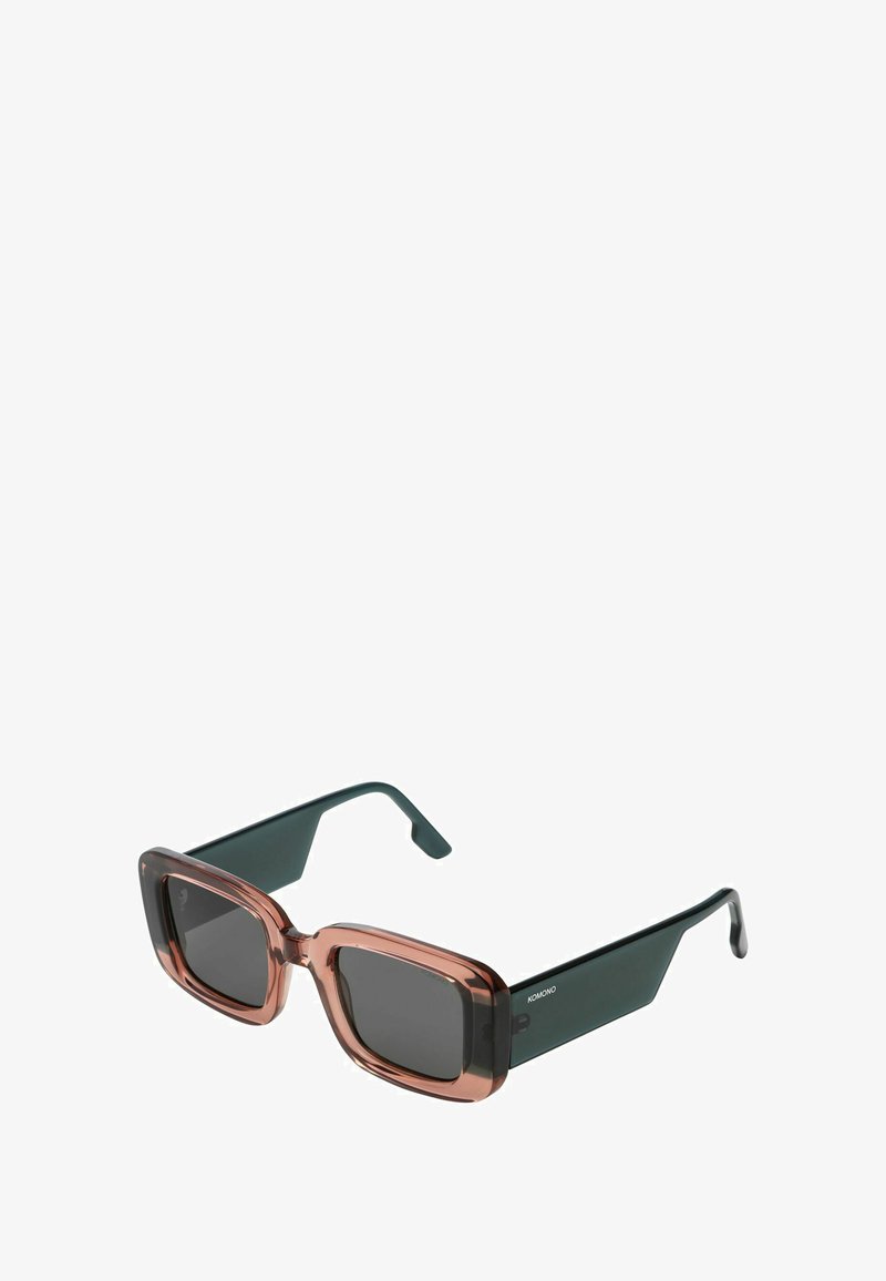 Lunettes de soleil carrées avec une monture vert foncé et des verres translucides marron. Elles possèdent des branches épaisses et un branding discret sur le côté.