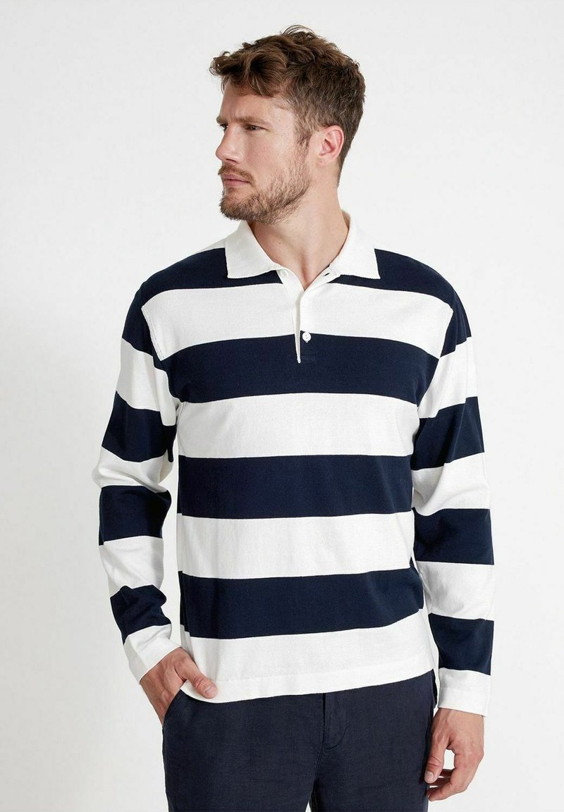 Polo a maniche lunghe in blu navy con strisce orizzontali bianche, con colletto e pattina a due bottoni, realizzato in tessuto testurizzato.