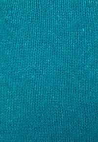 Türkiser Strickstoff mit glatter Oberfläche, der ein enges, einheitliches Muster und einen leichten Glanz aufweist, was auf synthetische Fasern hinweist.