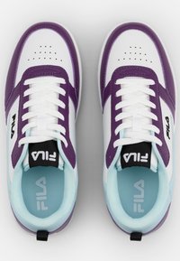 Weiße und lila Fila-Sneaker mit einem Obermaterial aus glattem Leder und Mesh, ausgestattet mit Perforationen, weißen Schnürsenkeln und einer hellblauen Innensohle.