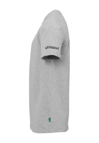 Grå bomulds T-shirt med korte ærmer, rund halsudskæring, og et sort logo "uhlsport" på venstre ærme. Sideetiket synlig.