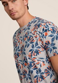 Korte mouwen, grijze katoenen T-shirt met een bloemenpatroon in blauw en oranje. Heeft een ronde hals en een gestructureerd stofontwerp.