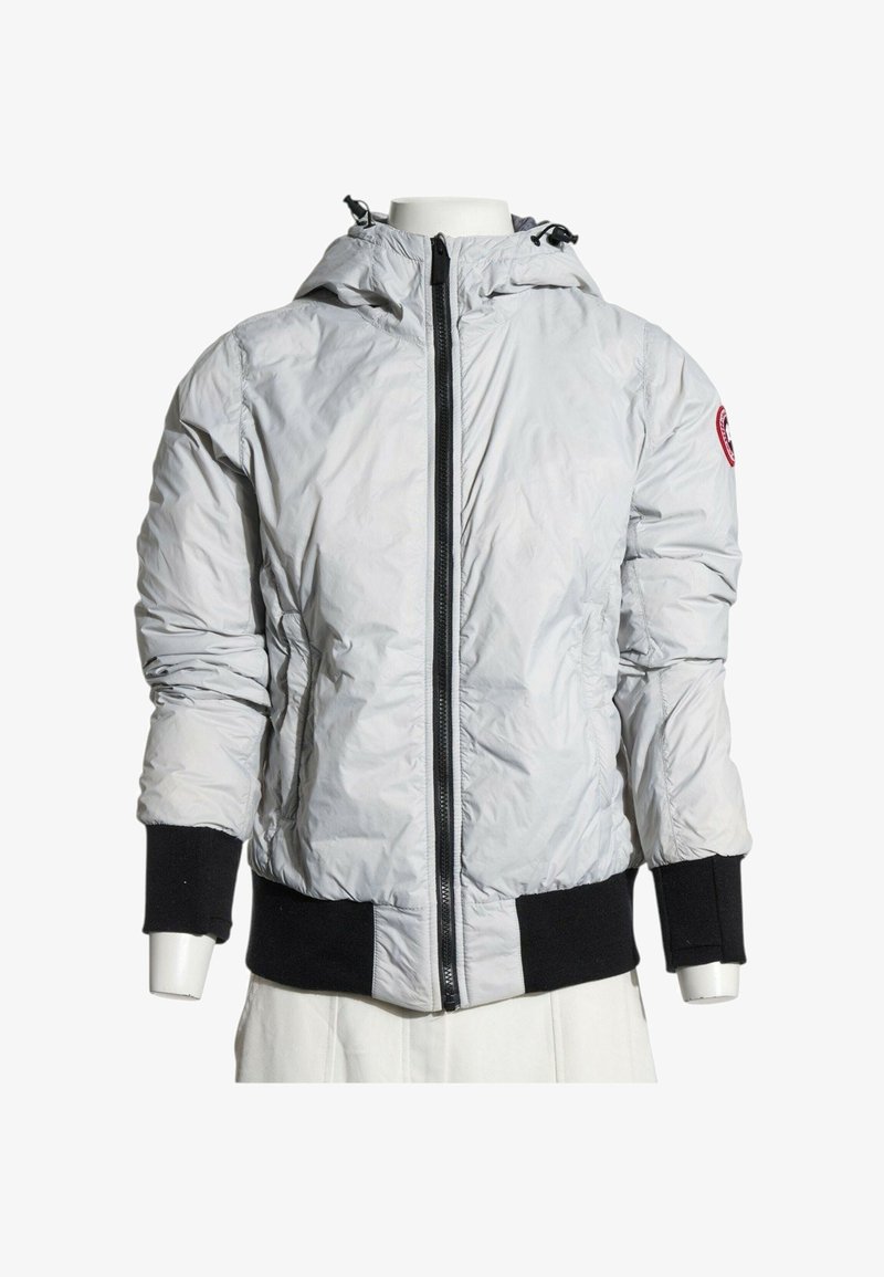 Veste à capuche gris clair avec fermeture éclair noire, poignets noirs et bande à la taille, présentée sur un buste de mannequin.