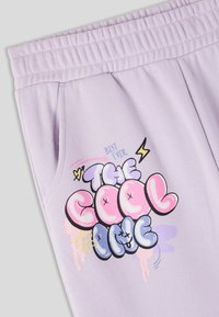 Pantaloni jogger lavanda con vita elastica, caratterizzati da un design in stile graffiti colorato che recita "IL PIÙ FICO" e "IL MIGLIORE DI SEMPRE".