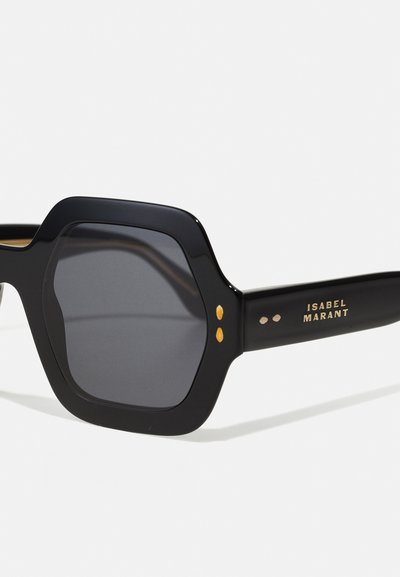 Occhiali da sole neri a forma ottagonale con lenti oscurate, dettagli dorati e finitura opaca. Logo "ISABEL MARANT" visibile sulla stanghetta.
