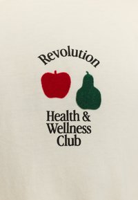 Witte katoenen shirt met een grafisch ontwerp van een rode appel en een groene peer, met de tekst "Revolution Health & Wellness Club" in zwarte letters.