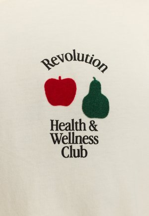 White cotton shirt featuring a red apple and green pear graphic, with the text “Revolution Health & Wellness Club” in black font.