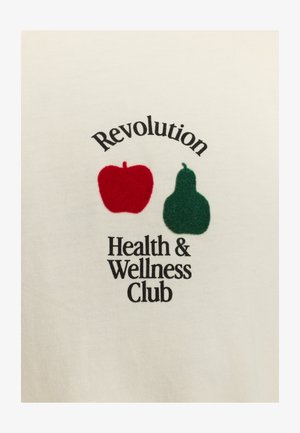 White cotton shirt featuring a red apple and green pear graphic, with the text “Revolution Health & Wellness Club” in black font.