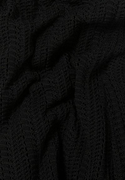 Tissu tricoté noir, présentant un motif texturé avec des mailles ouvertes et des nervures, créant une apparence superposée. Texture douce et flexible.