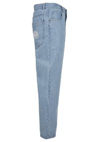 Jasnoniebieskie jeansy z denimu widziane z boku, z tylną kieszenią z tęczą i haftem logo "Southpole".