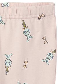 Helle rosa Stoffe mit skurrilen, cartoonhaften Charakteren mit blauer Haut, schwarzem Nähen und gelben Haaren, sowie pastellfarbenen Schleifen.