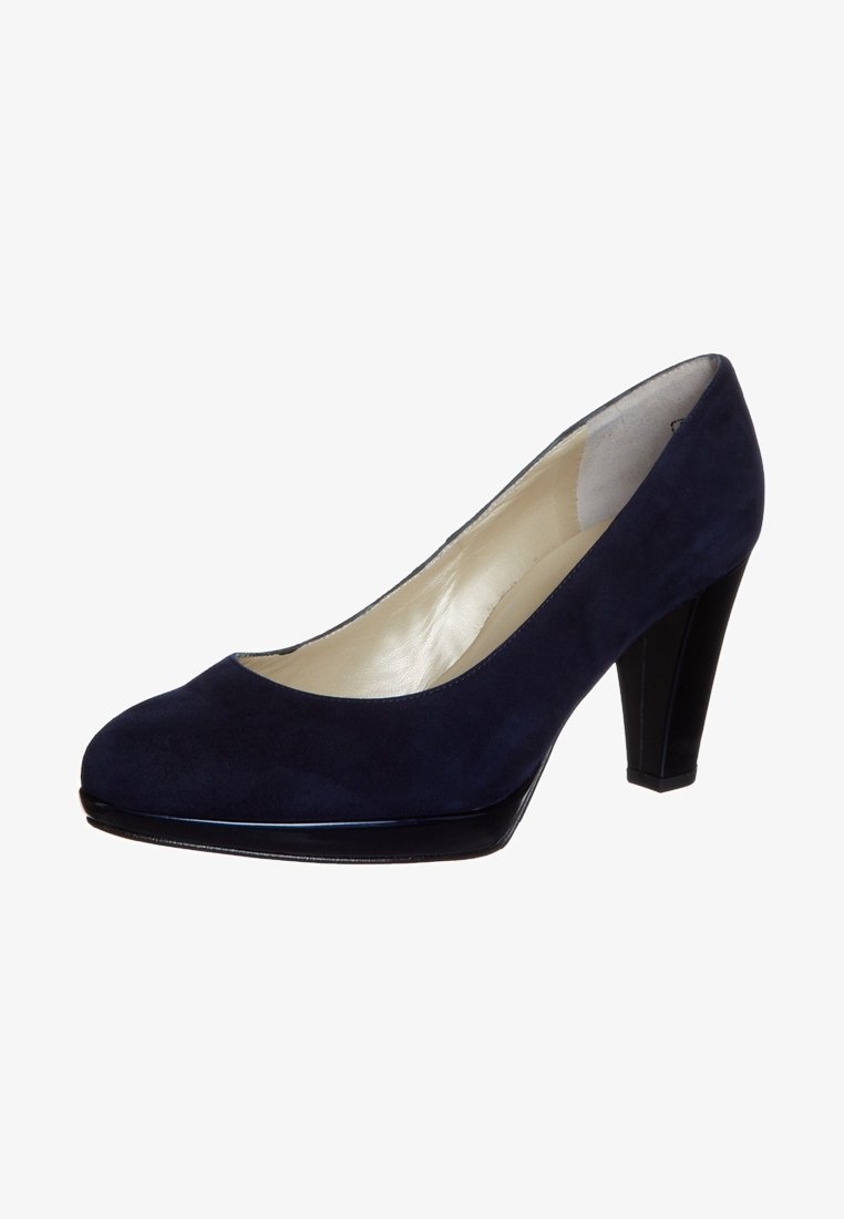 Escarpin en daim bleu marine avec un bout rond, accent noir brillant au niveau de la capant et un talon carré de 3 pouces. Doublure intérieure lisse.