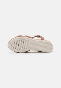 Sandalo in suede marrone con soletta imbottita, fibbia regolabile e suola in gomma testurizzata caratterizzata da fori di ventilazione e dettagli di branding.