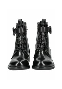 Botines de cuero negro con acabado brillante, cordones en la parte delantera, hebilla decorativa y cremallera en el lateral para poner y quitar fácilmente.