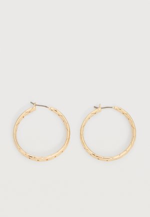 Pereche de cercei tip cerc, aurii cu textură, cu tije subțiri pe un fundal alb.