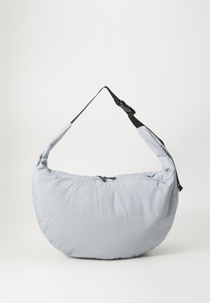 Light grey, padded shoulder bag with a half-moon shape, zip closure, and adjustable black strap. Soft texture with minimal branding.